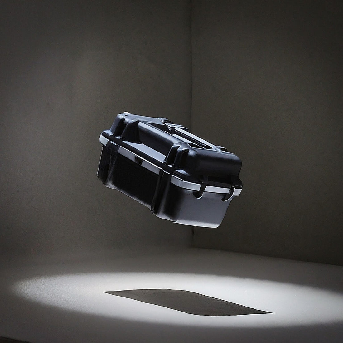 Black rugged protective case mid-air during drop test in studio lighting