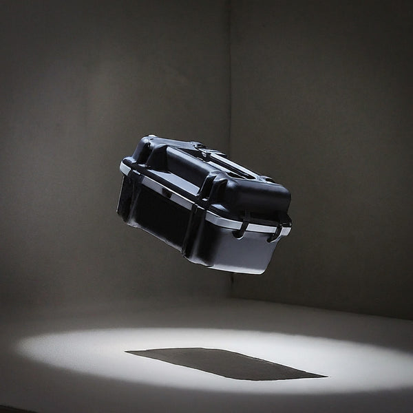 Black rugged protective case mid-air during drop test in studio lighting